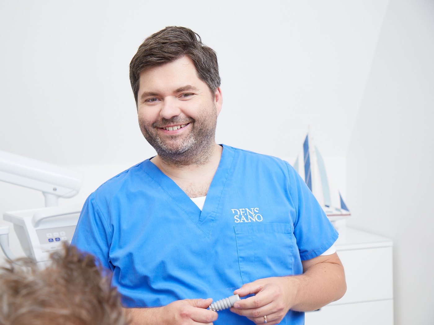 Jan Paehlke, Fachzahnarzt für Oralchirurgie, in der Praxis DensSano mit einem Implantat in der Hand